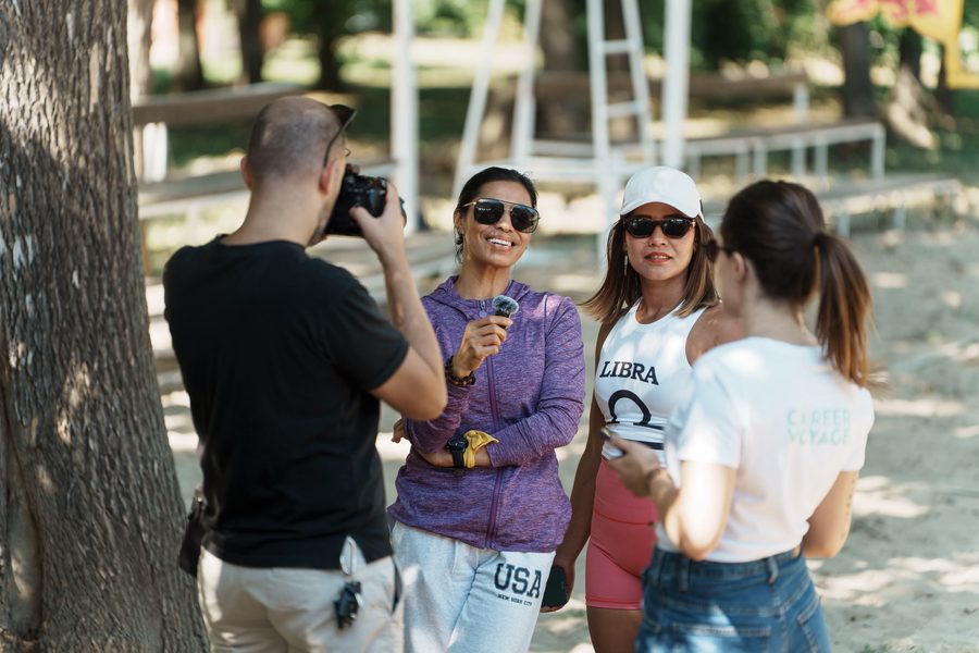Fotograf snima nasmejane učesnice pored terena